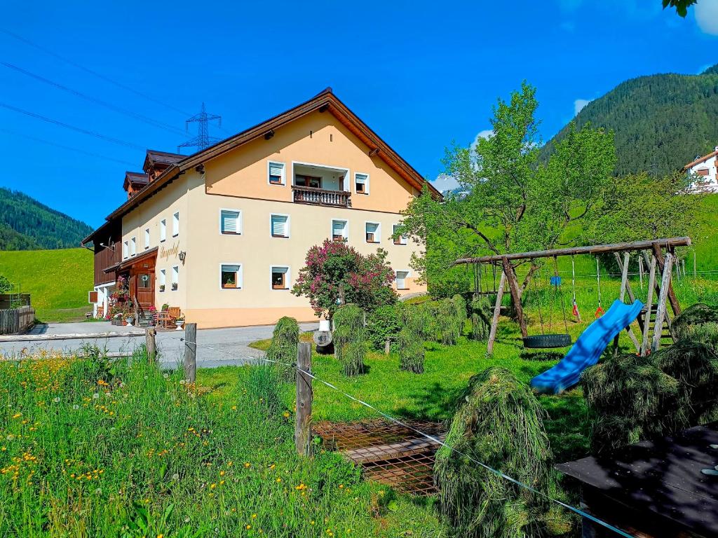 a house with a fence in front of a field at Burgerhof in Pettneu am Arlberg