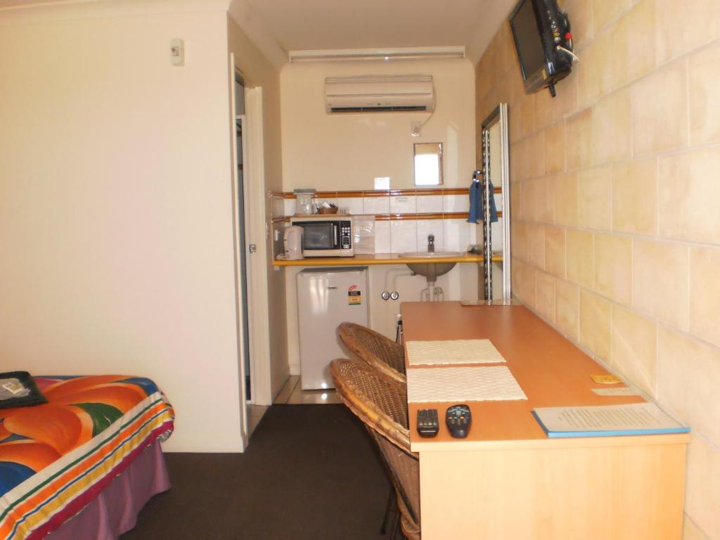 a bedroom with a bed and a desk at Country View Motel Ilbilbie in Ilbilbie