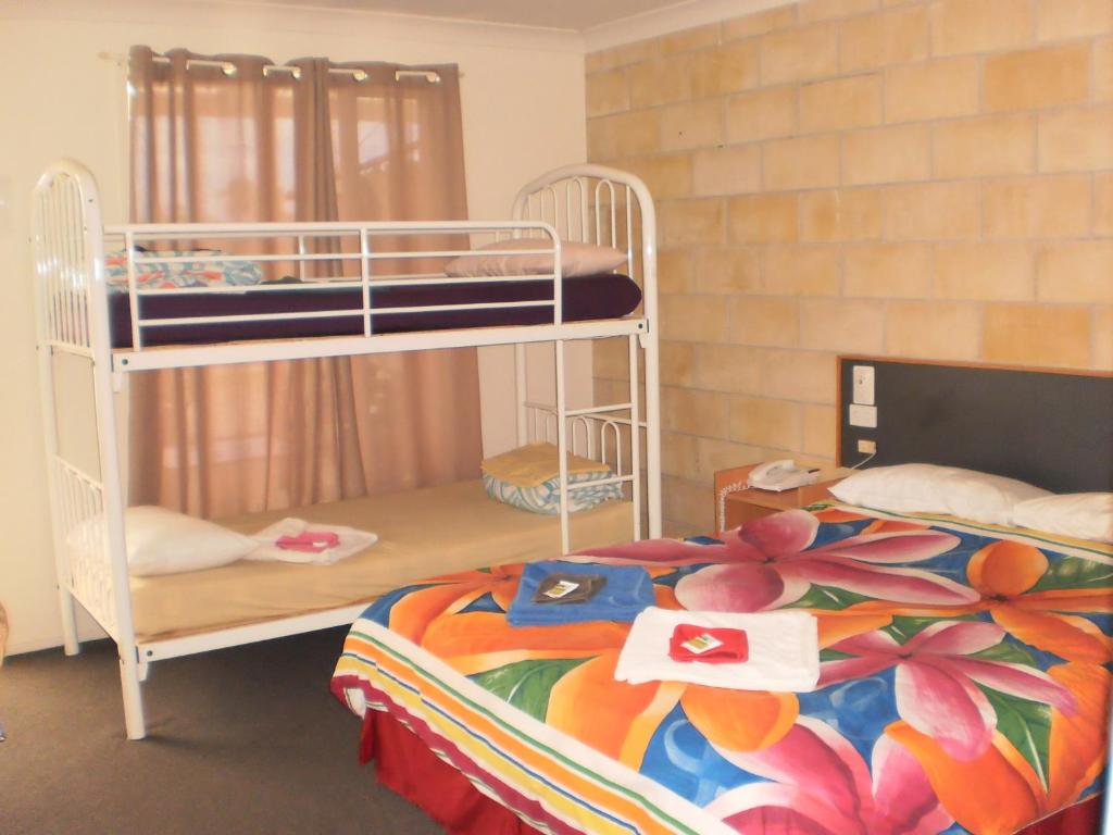 a bedroom with two bunk beds with a colorful blanket at Country View Motel Ilbilbie in Ilbilbie