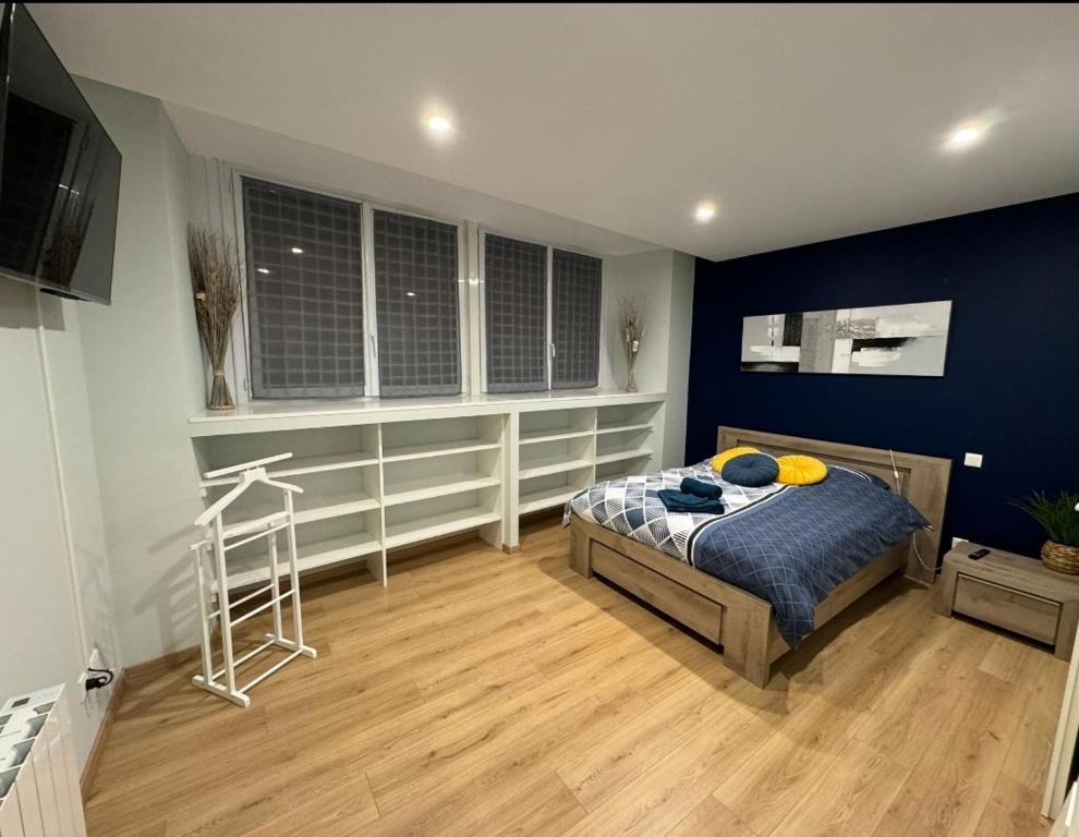 1 dormitorio con cama y pared azul en La Sout à découverte, en La Souterraine