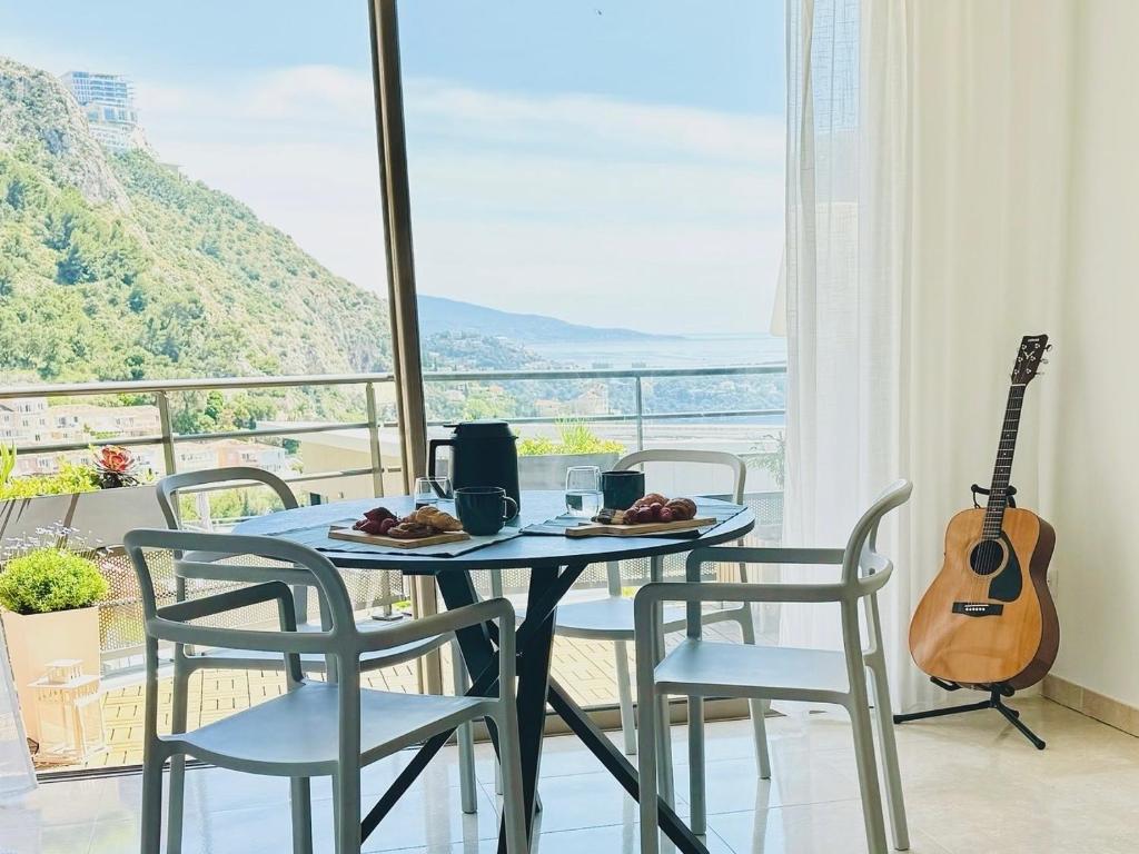 een tafel met een bord eten en een gitaar bij Penthouse over Monaco in Beausoleil