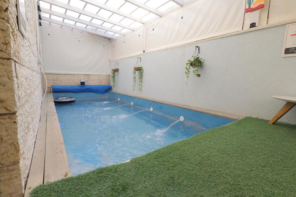 uma grande piscina interior num quarto com relva em אחוזת דולב-הצימר em Bet Shemesh