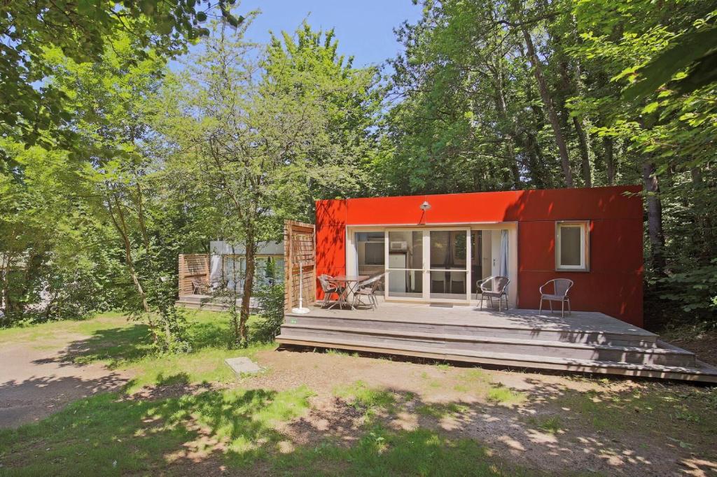 ein rotes winziges Haus im Wald in der Unterkunft Huttopia Royat in Royat