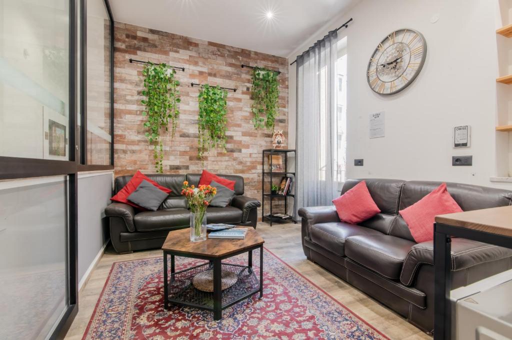 een woonkamer met twee leren banken en een tafel bij Panurban Rooms by Wonderful Italy in Palermo