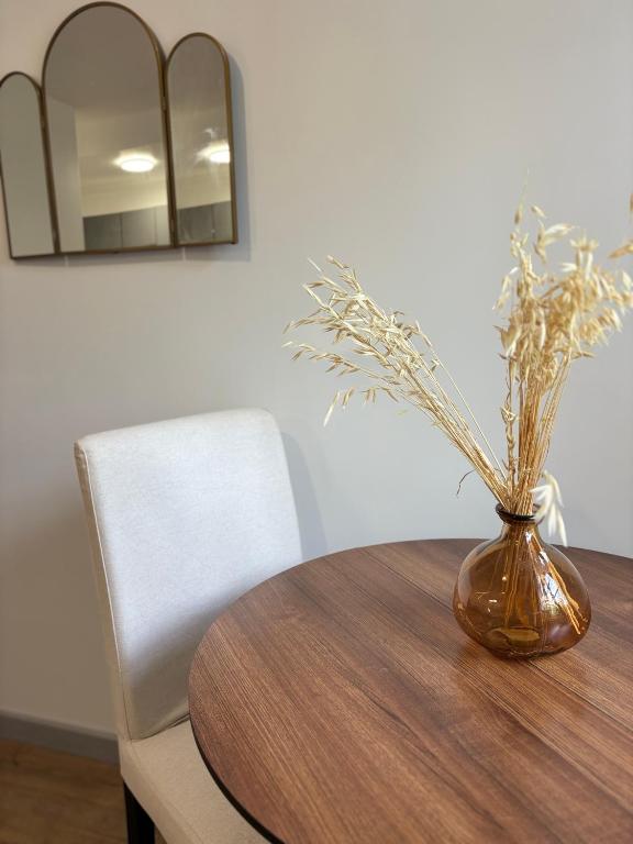 un vase assis sur une table en bois avec un vase dans l'établissement Green view studio, à Couzon-au-Mont-dʼOr