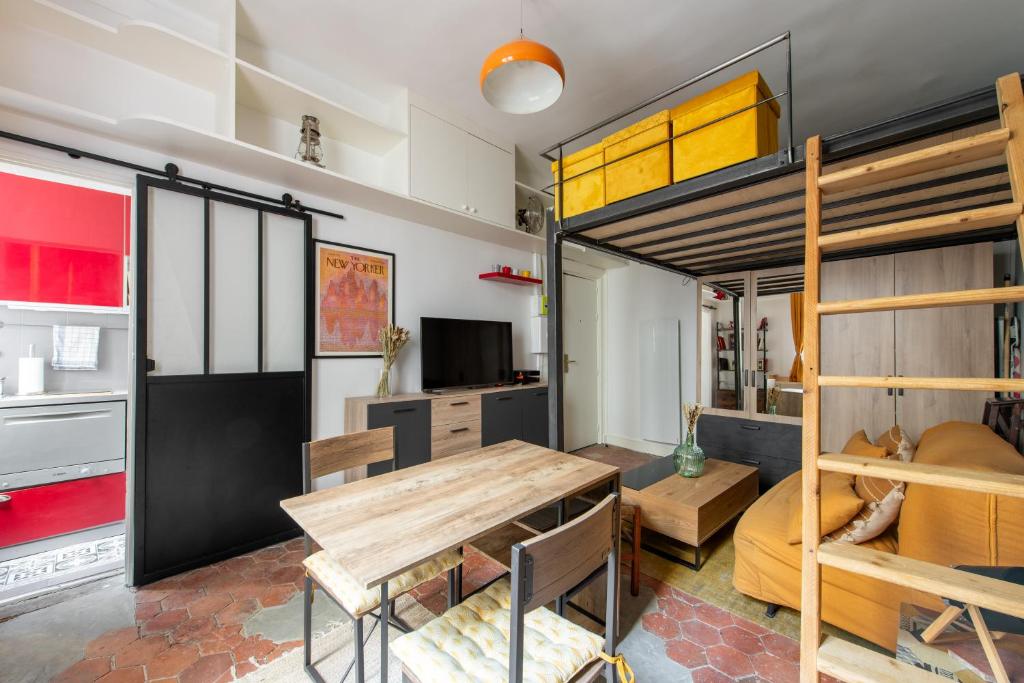 Cette chambre comprend une table et des lits superposés. dans l'établissement Géranimus CLERY: Heart of Paris, à Paris