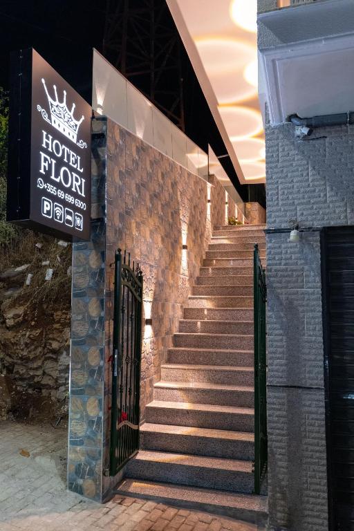 un conjunto de escaleras con un cartel en un edificio en Hotel Flori, en Sarandë