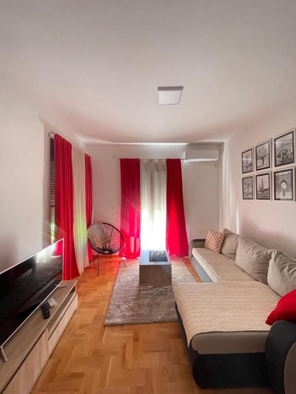 a living room with a couch and red curtains at Marina in Budva