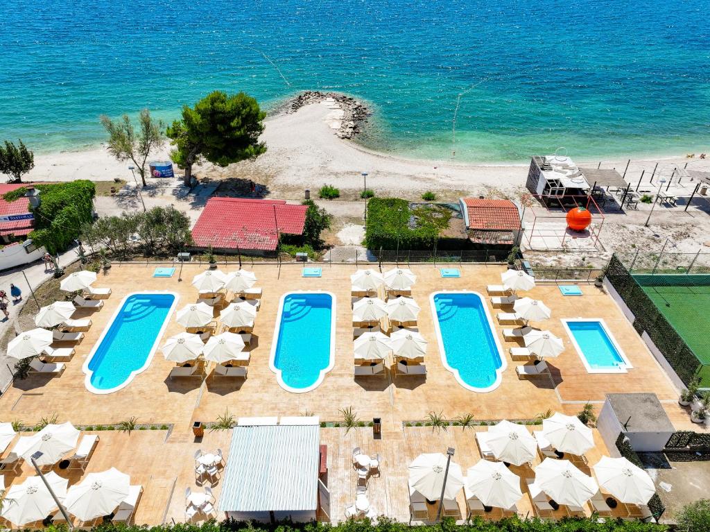 an aerial view of a resort with swimming pools and umbrellas at Apartments Medena in Trogir