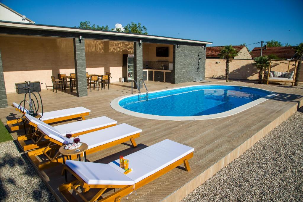 een patio met een zwembad en een terras met ligstoelen bij Old Tower in Stolac