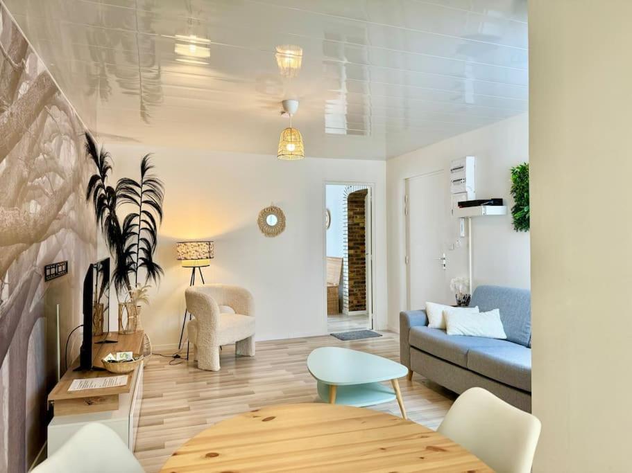 un salon avec un canapé et une table dans l'établissement Le Vendays Reims plein de charme, à Reims