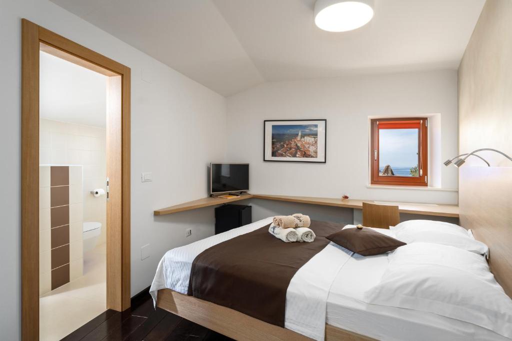 a bedroom with a bed with a teddy bear on it at Boutique Wrungel in Vrsar