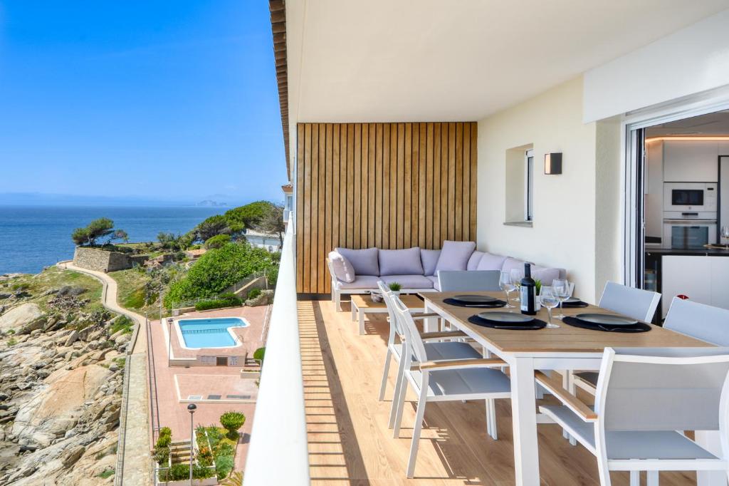 a dining room with a table and chairs and the ocean at Ático Crucero Suite VIP in Roses