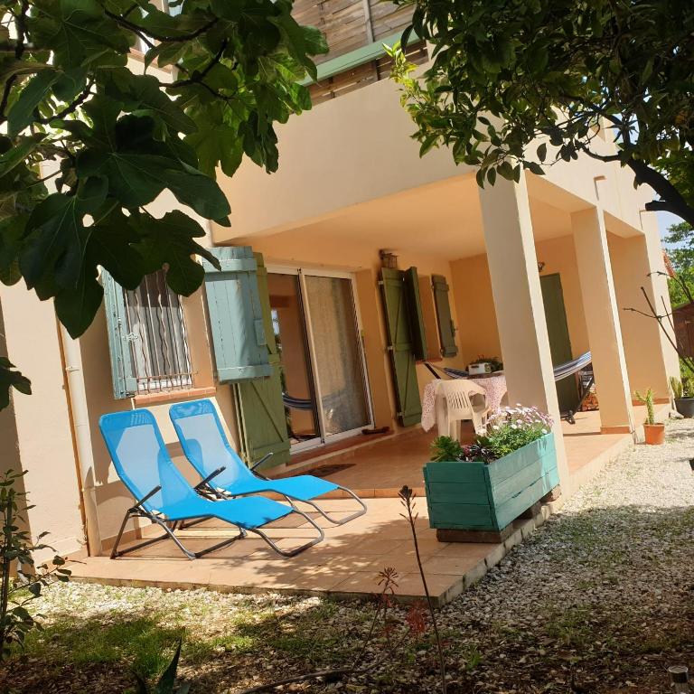 une chaise bleue assise sur la terrasse couverte d'une maison dans l'établissement L'Oliveraie, à Hyères