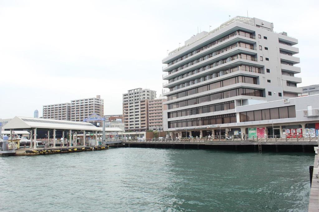 a large building next to a river with buildings at Shimonoseki Grand Hotel in Shimonoseki