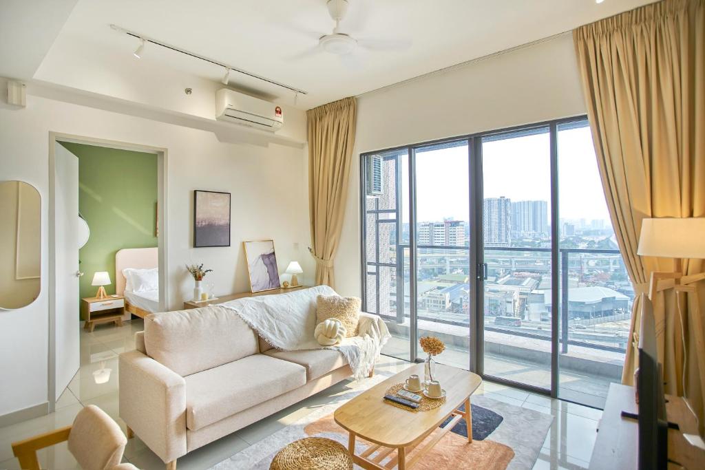 a living room with a couch and a large window at Trion Kuala Lumpur by Cobnb in Kuala Lumpur