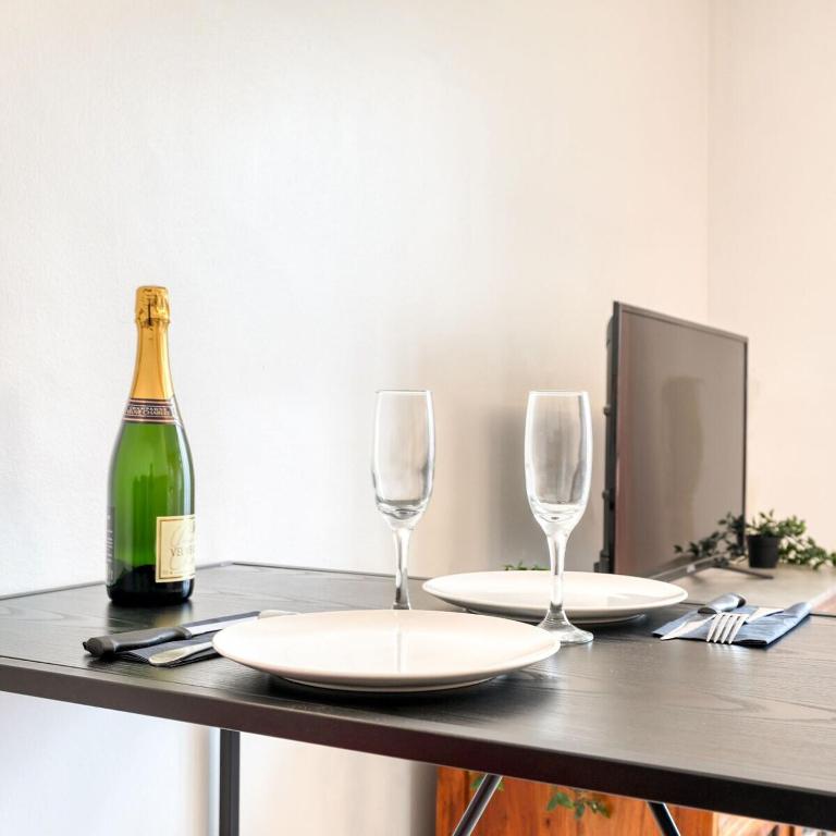un tavolo con due bicchieri e una bottiglia di vino di Samois-sur-seine Superbe appartement - Rickhoss Home a Samois-sur-Seine