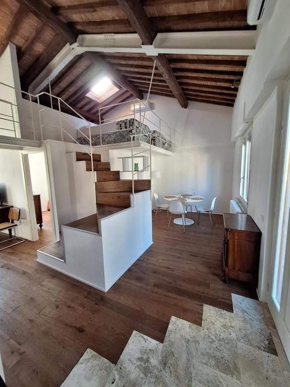 a living room with a staircase and a table at il "Terrazzino" nel cuore di Siena in Siena