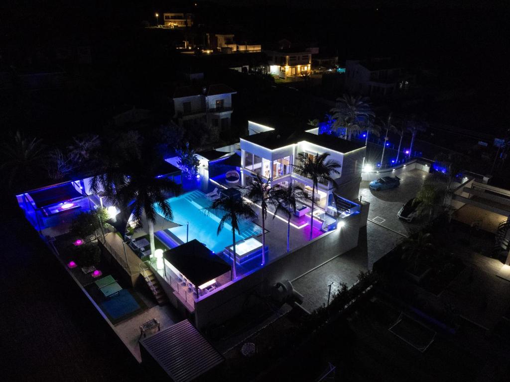 - une vue aérienne sur une maison aux lumières bleue et violette dans l'établissement Rent Private Villa 011, à Protaras