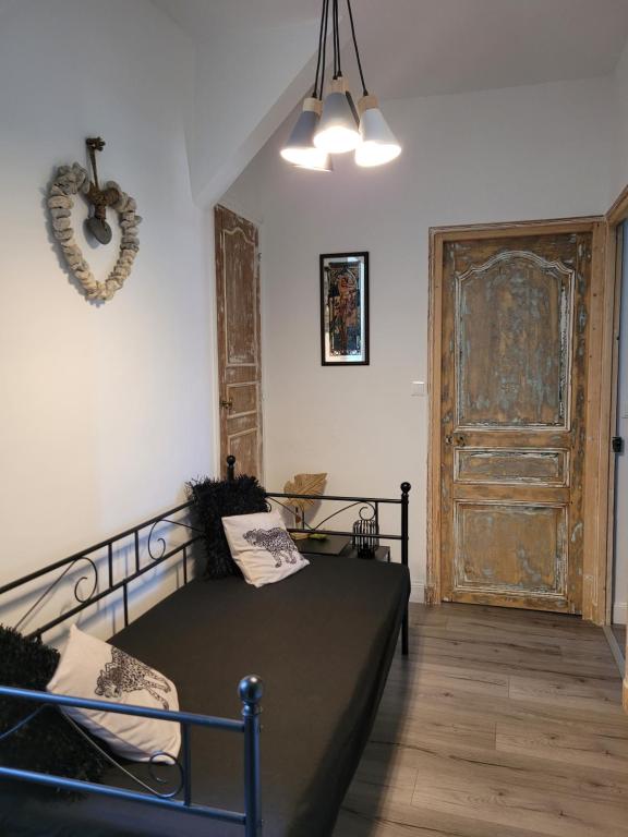 a bedroom with a bed and a large wooden door at LE MANOIR PARADI in Presles-et-Thierny