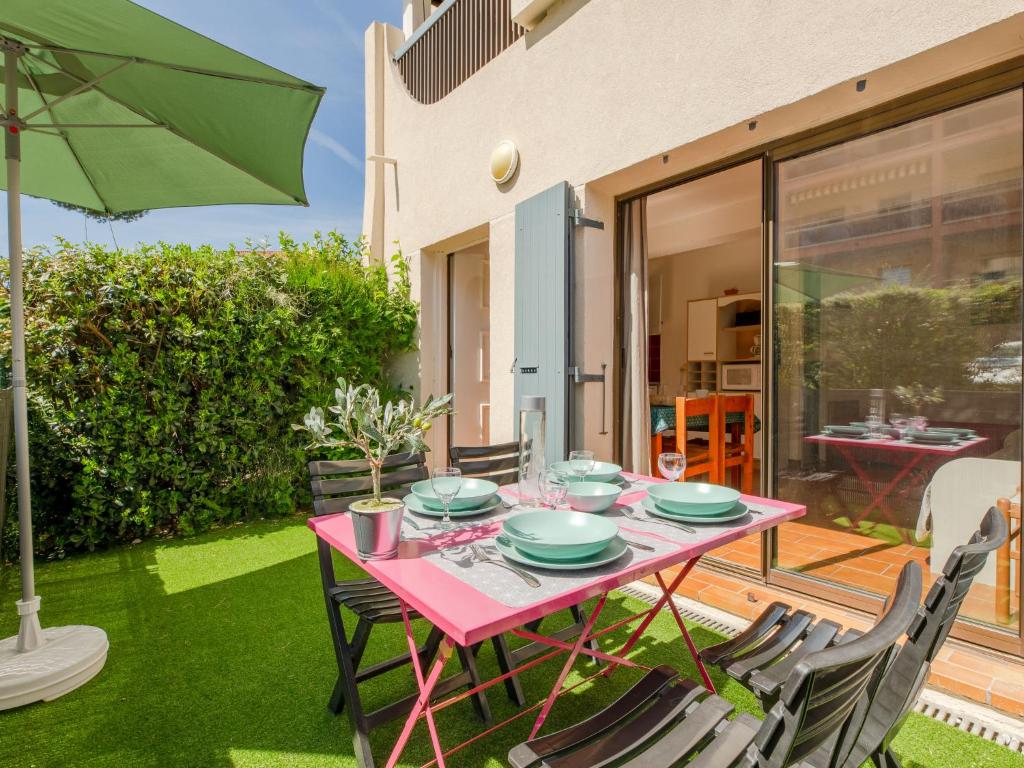 une table rose avec des chaises et un parasol dans l'établissement Studio Les Coralines-3 by Interhome, à Sainte-Maxime