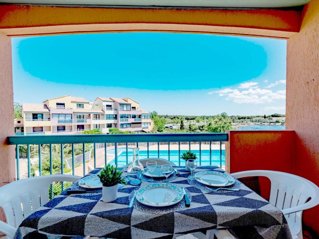 - une table sur un balcon avec vue sur un bâtiment dans l'établissement Apartment Les Barcarelles by Interhome, au Barcarès