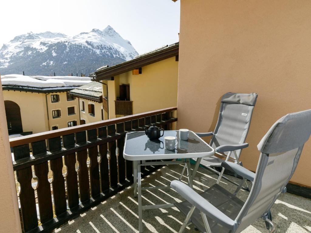 uma mesa e duas cadeiras numa varanda com montanhas em Apartment Residenza Chesa Margun 57-1 by Interhome em Surlej