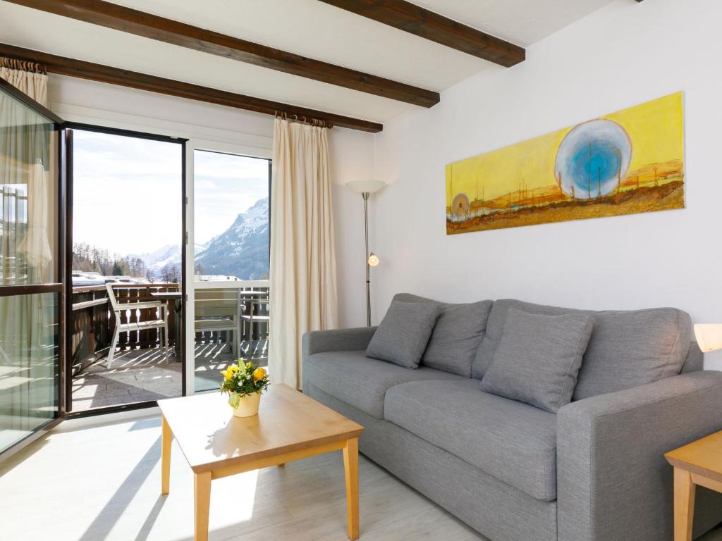 a living room with a couch and a table at Apartment Residenza Chesa Margun 58-5 by Interhome in Surlej