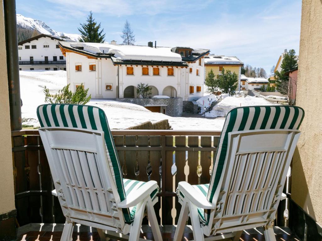 two lawn chairs sitting on a balcony with snow at Apartment Residenza Chesa Margun 13-6 by Interhome in Surlej