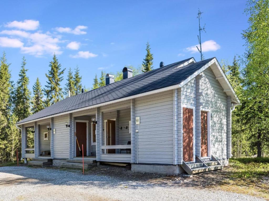a small white house with a roof at Holiday Home Isonparit b3 by Interhome in Ylläsjärvi