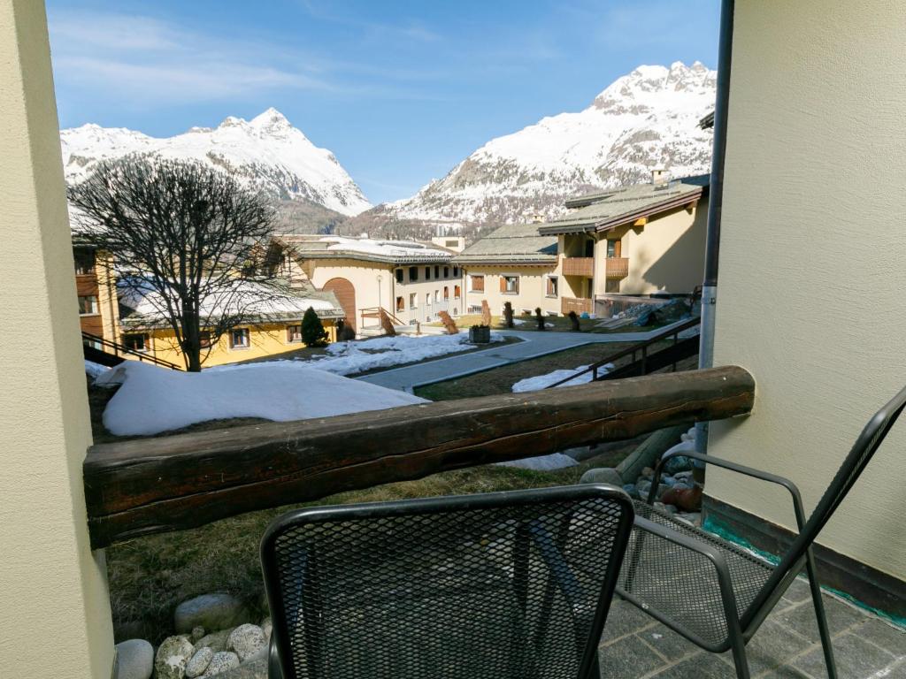 a balcony with a chair and snow covered mountains at Apartment Residenza Chesa Margun 66-1 by Interhome in Surlej