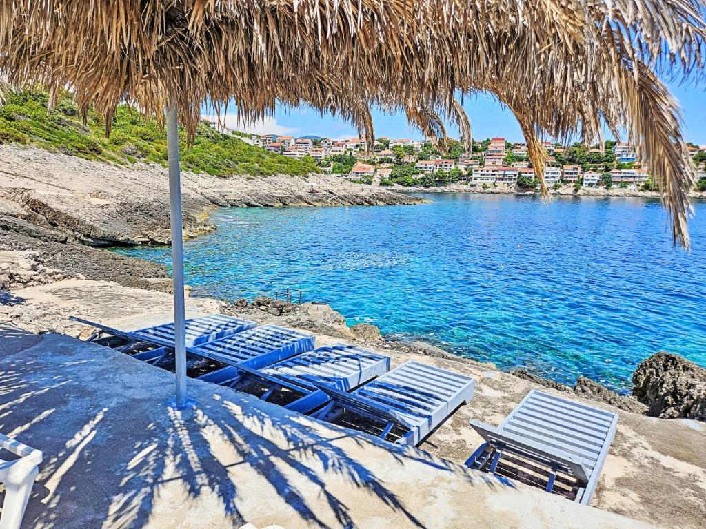 grupa krzeseł i parasol na plaży w obiekcie Apartment Snježana-5 by Interhome w mieście Zavalatica