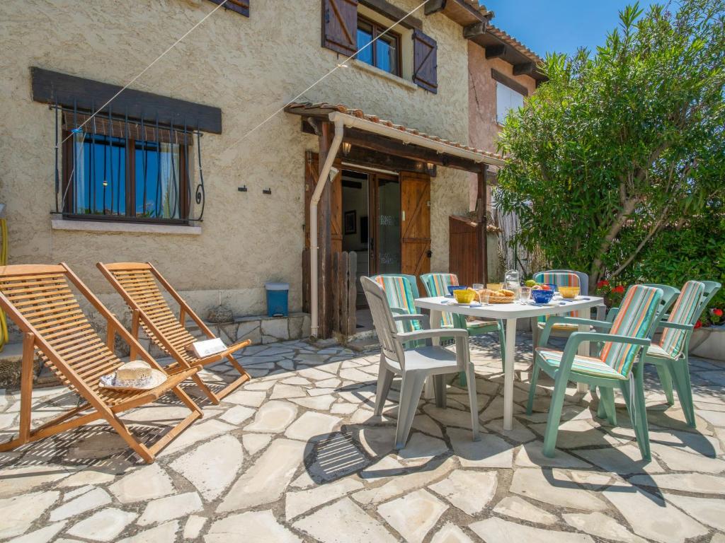 un patio avec une table et des chaises devant une maison dans l'établissement Holiday Home Les Jardins de Sinople by Interhome, à La Madrague