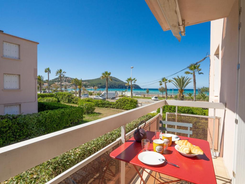 - une table rouge sur un balcon avec vue sur l'océan dans l'établissement Apartment La Sirene-4 by Interhome, aux Lecques