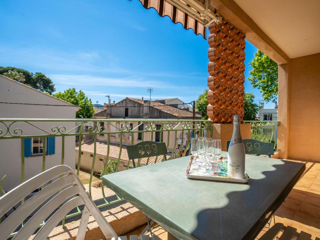 - une table sur un balcon avec une bouteille de vin dans l'établissement Apartment Les Mimosas by Interhome, aux Lecques