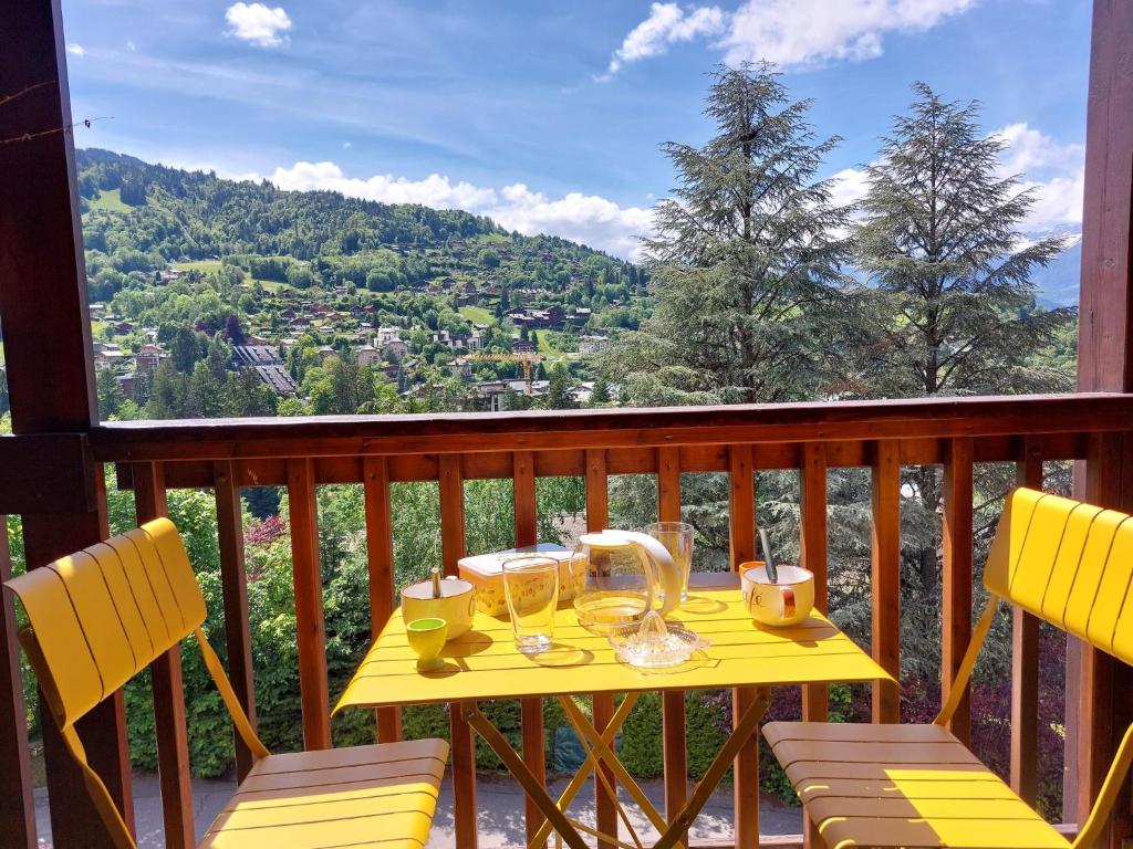 une table jaune avec des verres au sommet d'un balcon dans l'établissement Apartment Martagon-2 by Interhome, à Saint-Gervais-les-Bains