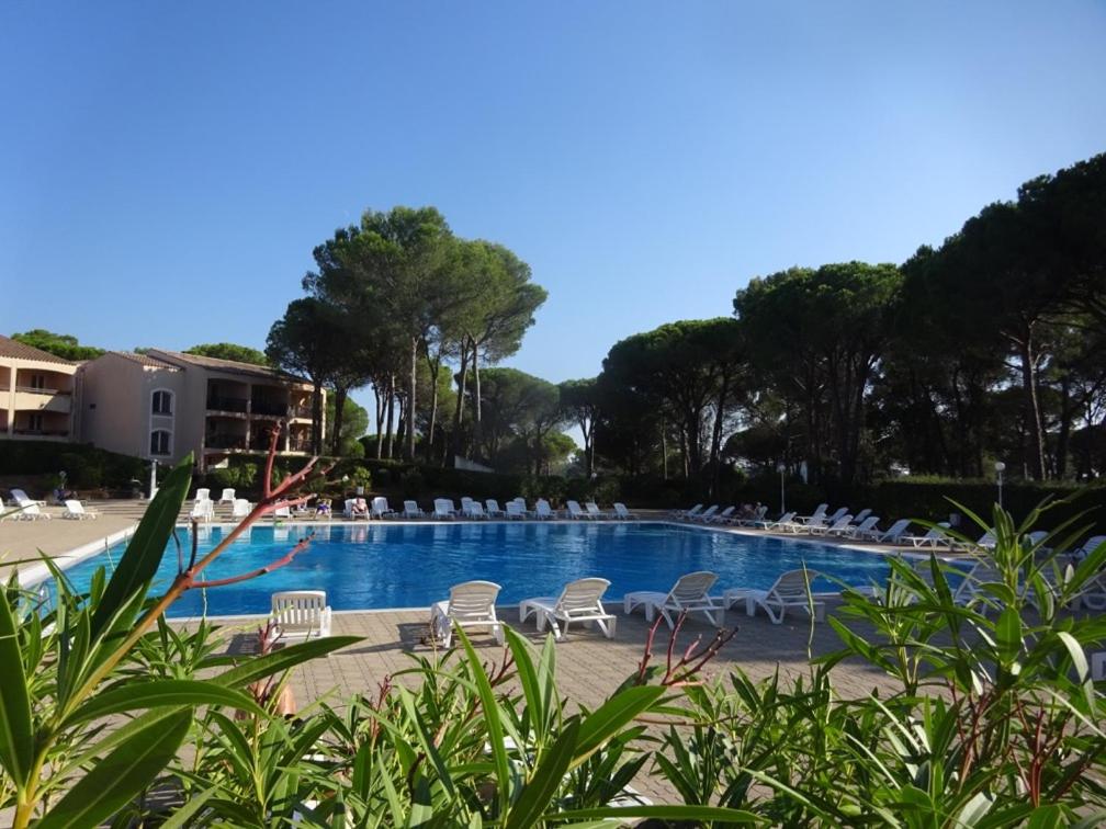 a swimming pool with lounge chairs and a swimming pool at Domaine de Valescure T3 Rez De Jardin in Saint-Raphaël