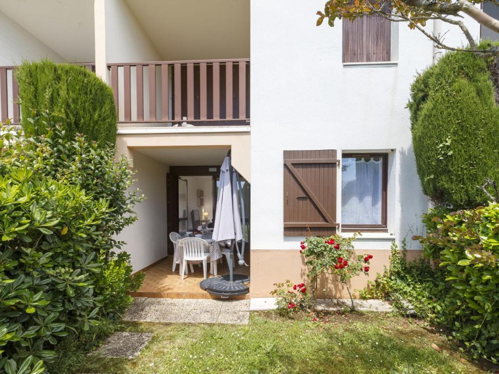 ein Haus mit einer Terrasse, einem Tisch und einem Sonnenschirm in der Unterkunft Apartment Les Balcons de l'Atlantique-15 by Interhome in Vaux-sur-Mer
