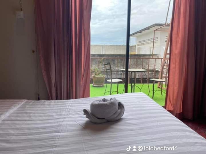 - une serviette sur un lit avec vue sur le patio dans l'établissement the L Hua Hin, à Hua Hin