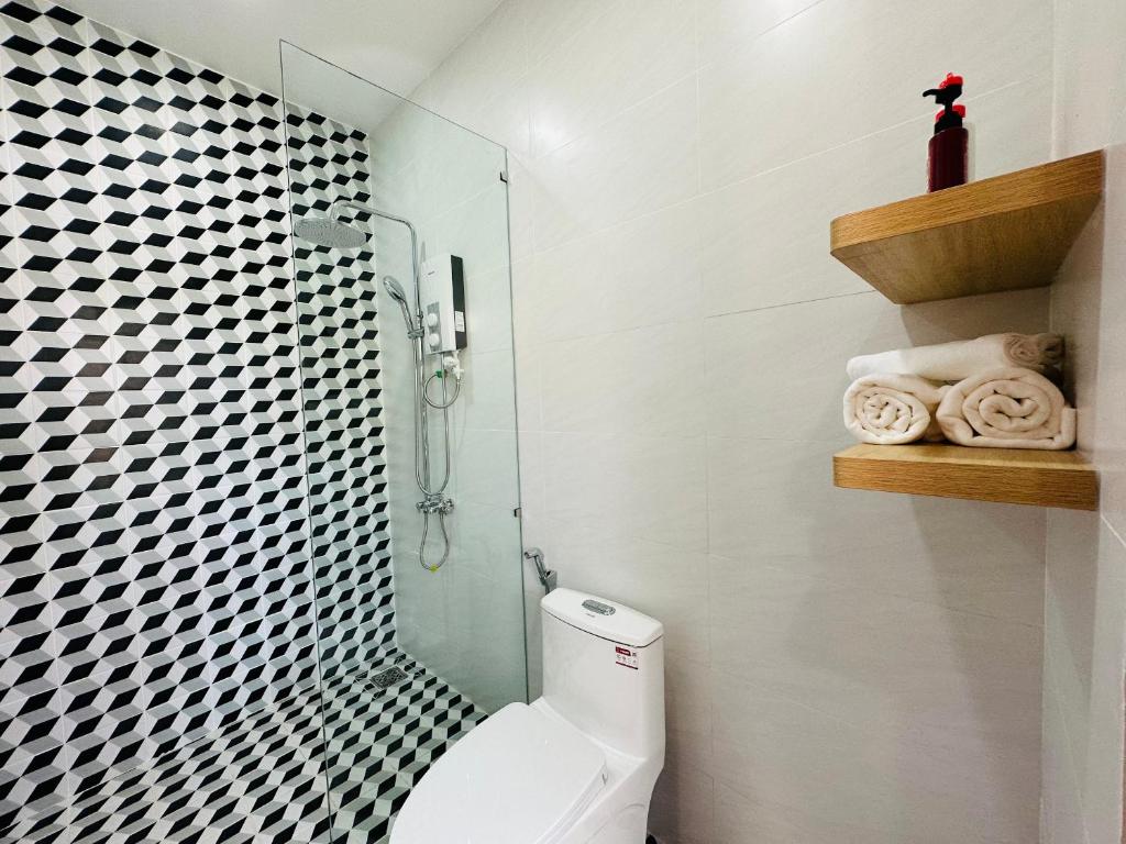 a bathroom with a toilet and a glass shower at MON House in Ấp Sung Xuân