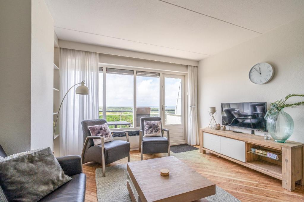 a living room with a couch and a tv at Appartementencomplex Juliana 146 in De Koog