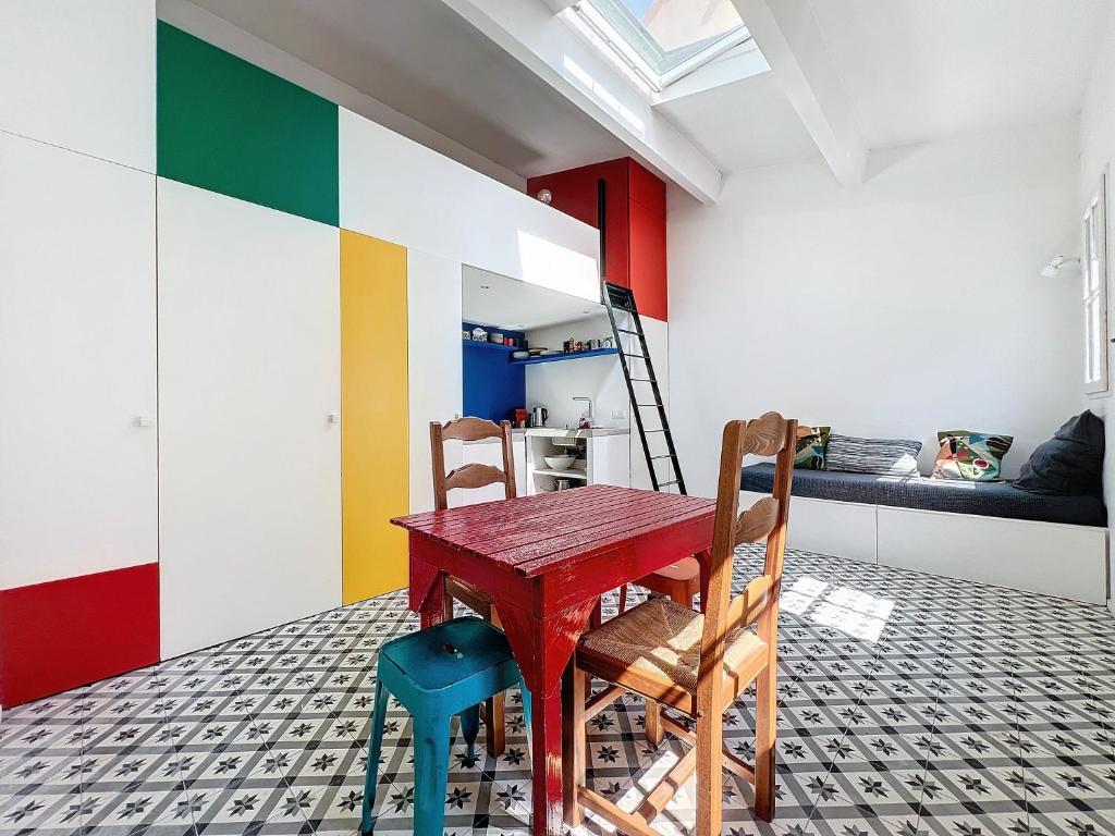- une salle à manger avec une table rouge et deux chaises dans l'établissement Cabanon de Pêcheur - Vallon des Auffes - Les Frères de la Loc', à Marseille