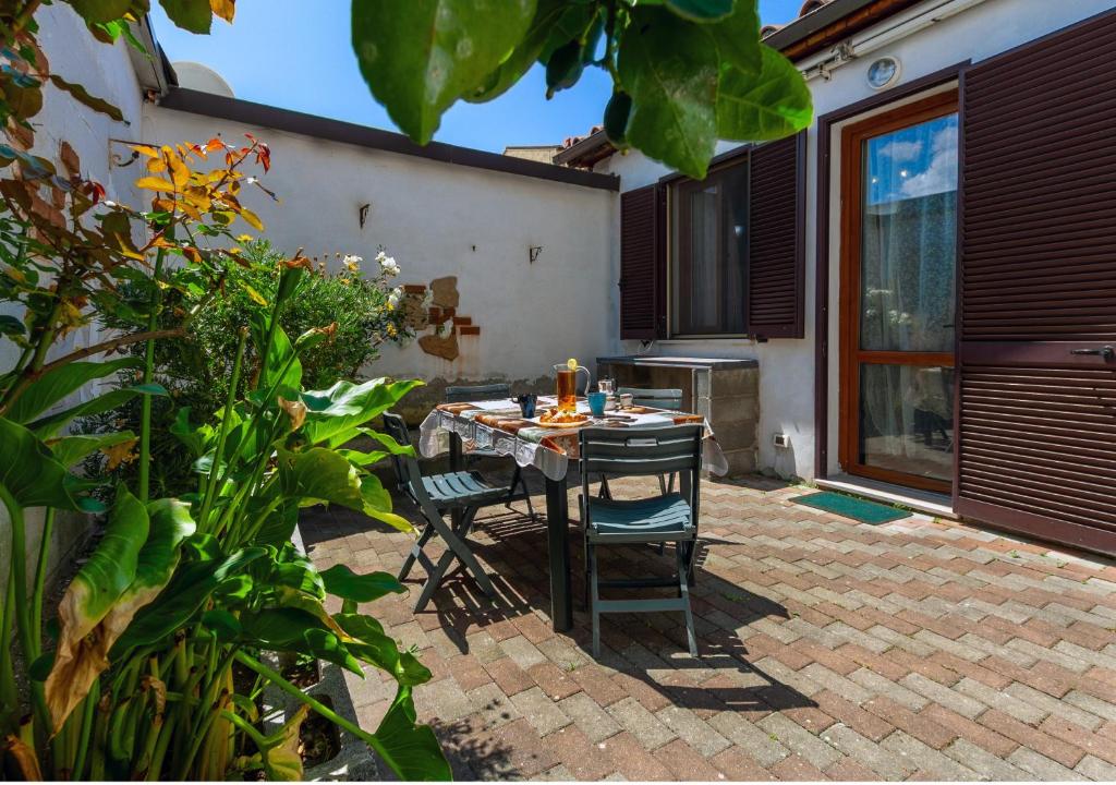 a patio with a table and chairs in a yard at Camy Wine House con giardino vicino alla stazione ferroviaria in Livorno