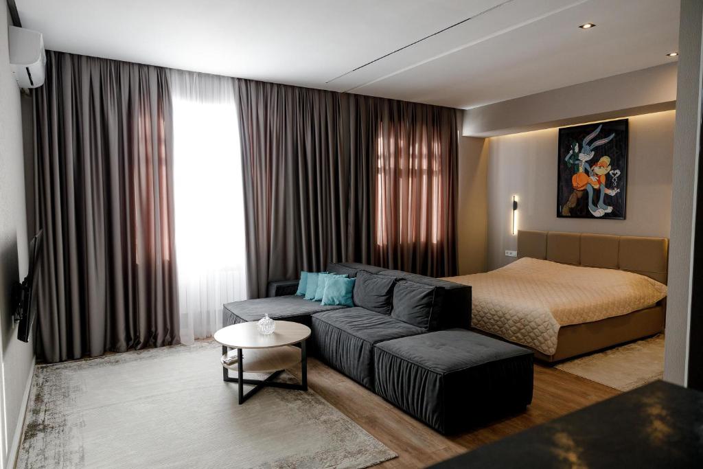 a living room with a couch and a bed at Апартаменты в ЖК Green Plaza с джакузи in Aktau