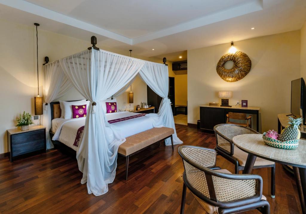 a bedroom with a white bed with a canopy at Bali Sunshine Nusa Dua in Nusa Dua
