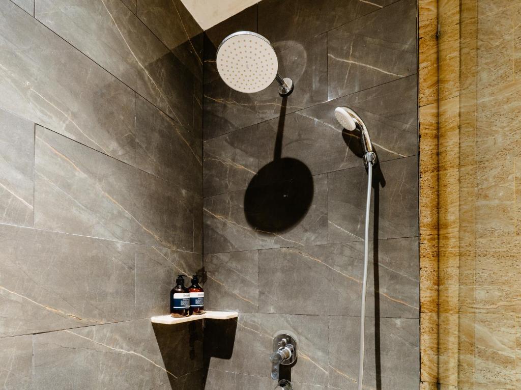 a shower with a shower head in a bathroom at Bali Sunshine Nusa Dua in Nusa Dua