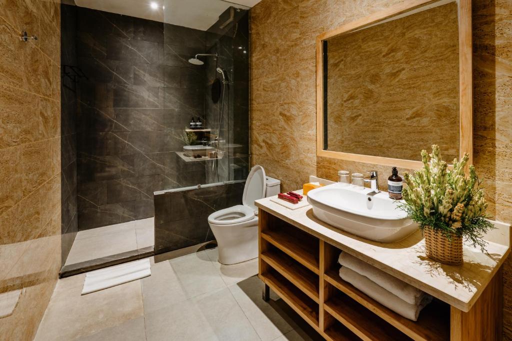 a bathroom with a sink and a shower and a toilet at Bali Sunshine Nusa Dua in Nusa Dua