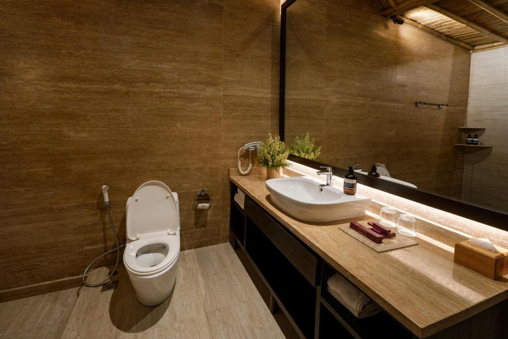 a bathroom with a toilet and a sink at Bali Sunshine Nusa Dua in Nusa Dua