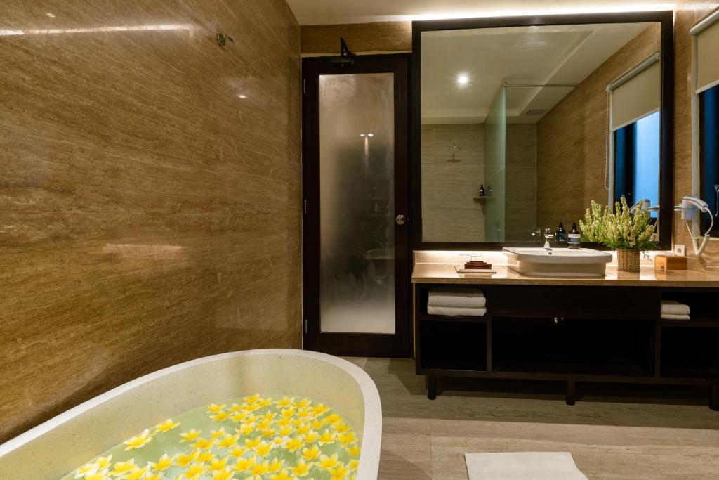 a bathroom with a bath tub and a sink at Bali Sunshine Nusa Dua in Nusa Dua