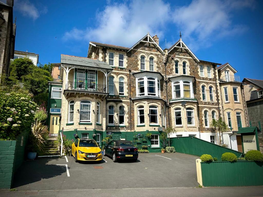 um carro amarelo estacionado em frente a um grande edifício em The Earlsdale Bed and Breakfast em Ilfracombe